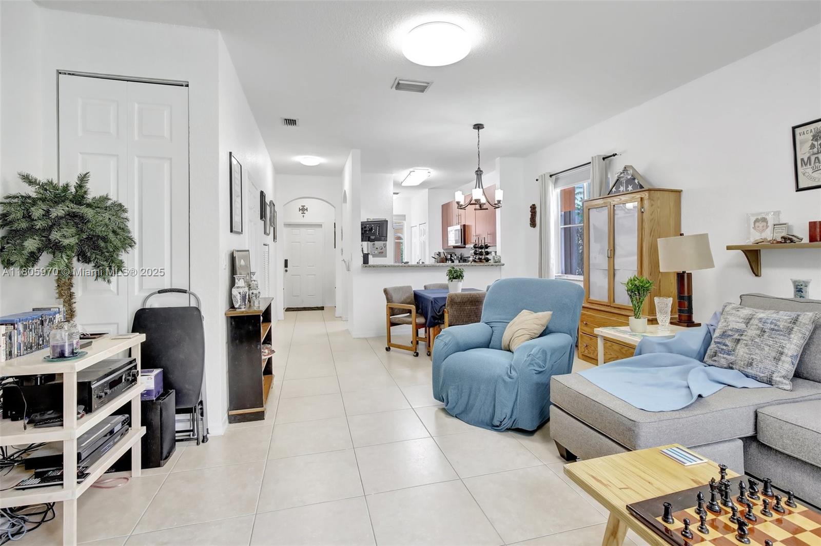 8999 Southwest 18th Street, Unit 1401 Miramar, FL 33025 - Photo 33 of 51 a living room with furniture and a chandelier