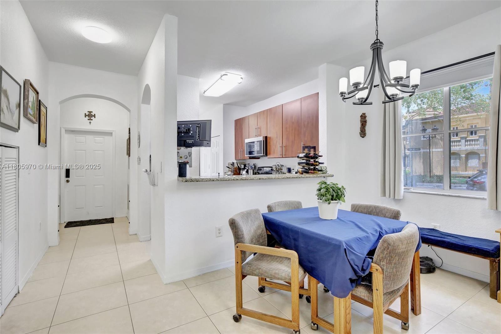 8999 Southwest 18th Street, Unit 1401 Miramar, FL 33025 - Photo 35 of 51 a view of a dining room with furniture and a chandelier