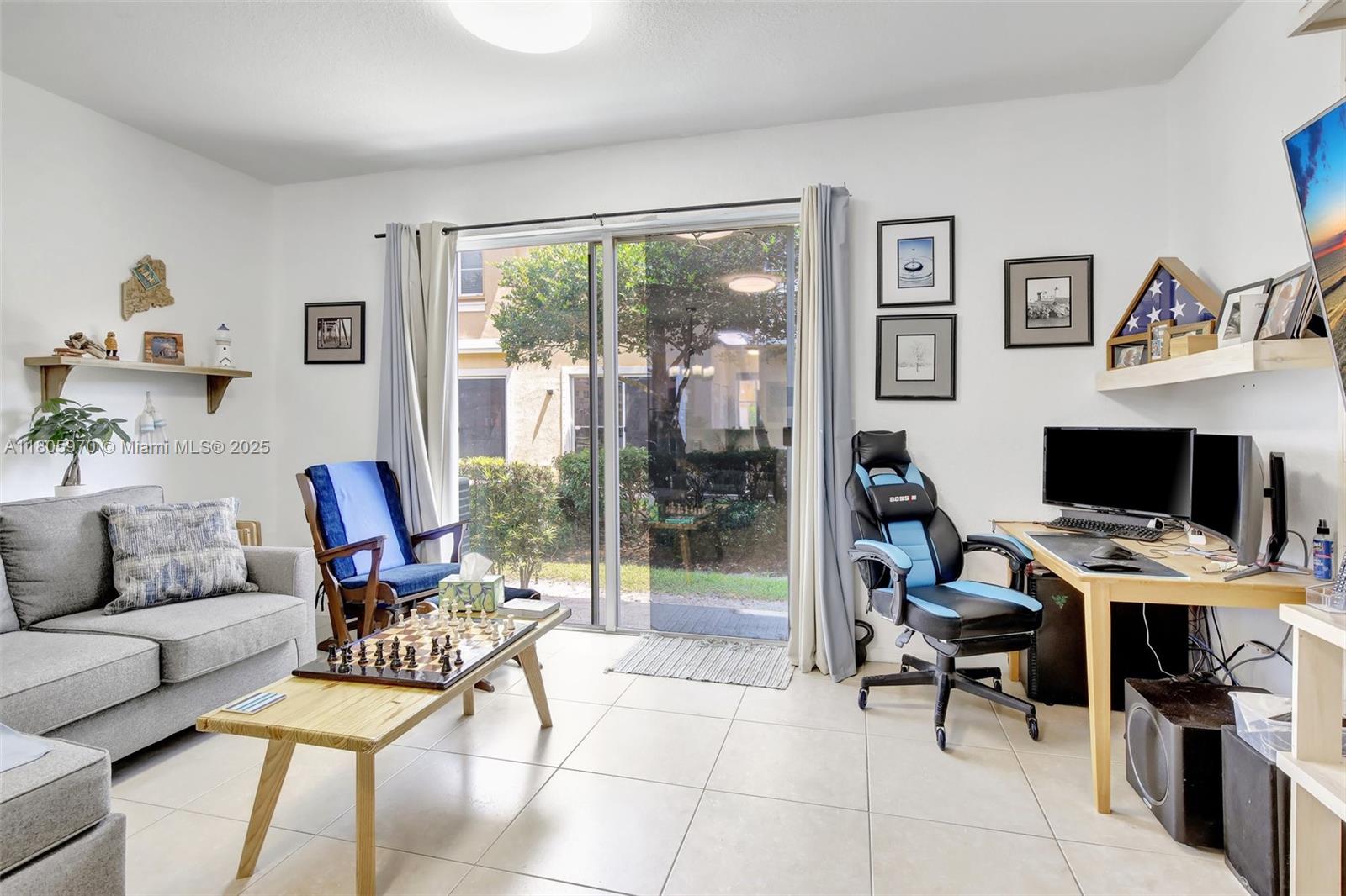 8999 Southwest 18th Street, Unit 1401 Miramar, FL 33025 - Photo 38 of 51 a workspace with furniture and a floor to ceiling window