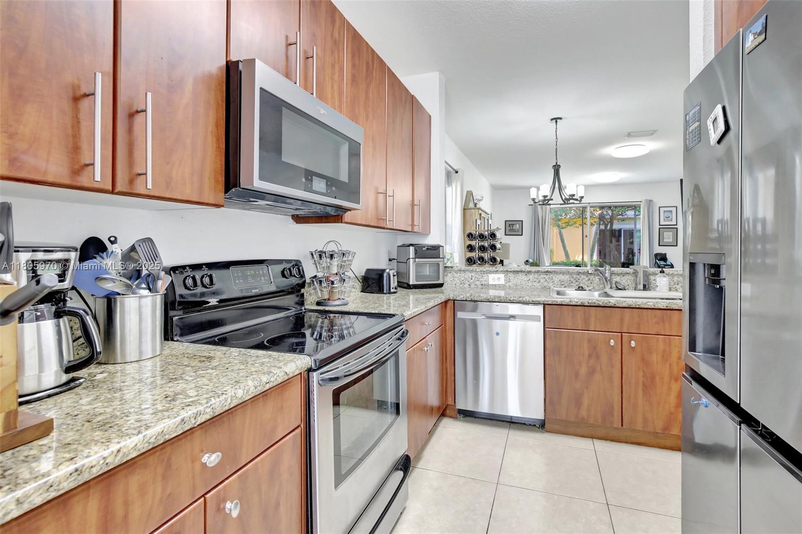 8999 Southwest 18th Street, Unit 1401 Miramar, FL 33025 - Photo 39 of 51 a kitchen with stainless steel appliances granite countertop a sink a stove and cabinets