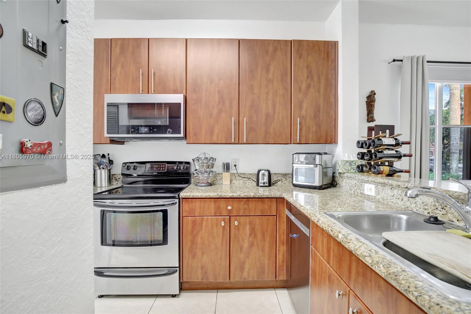 8999 Southwest 18th Street, Unit 1401 Miramar, FL 33025 - Photo 42 of 51 a kitchen with stainless steel appliances granite countertop a stove microwave and sink
