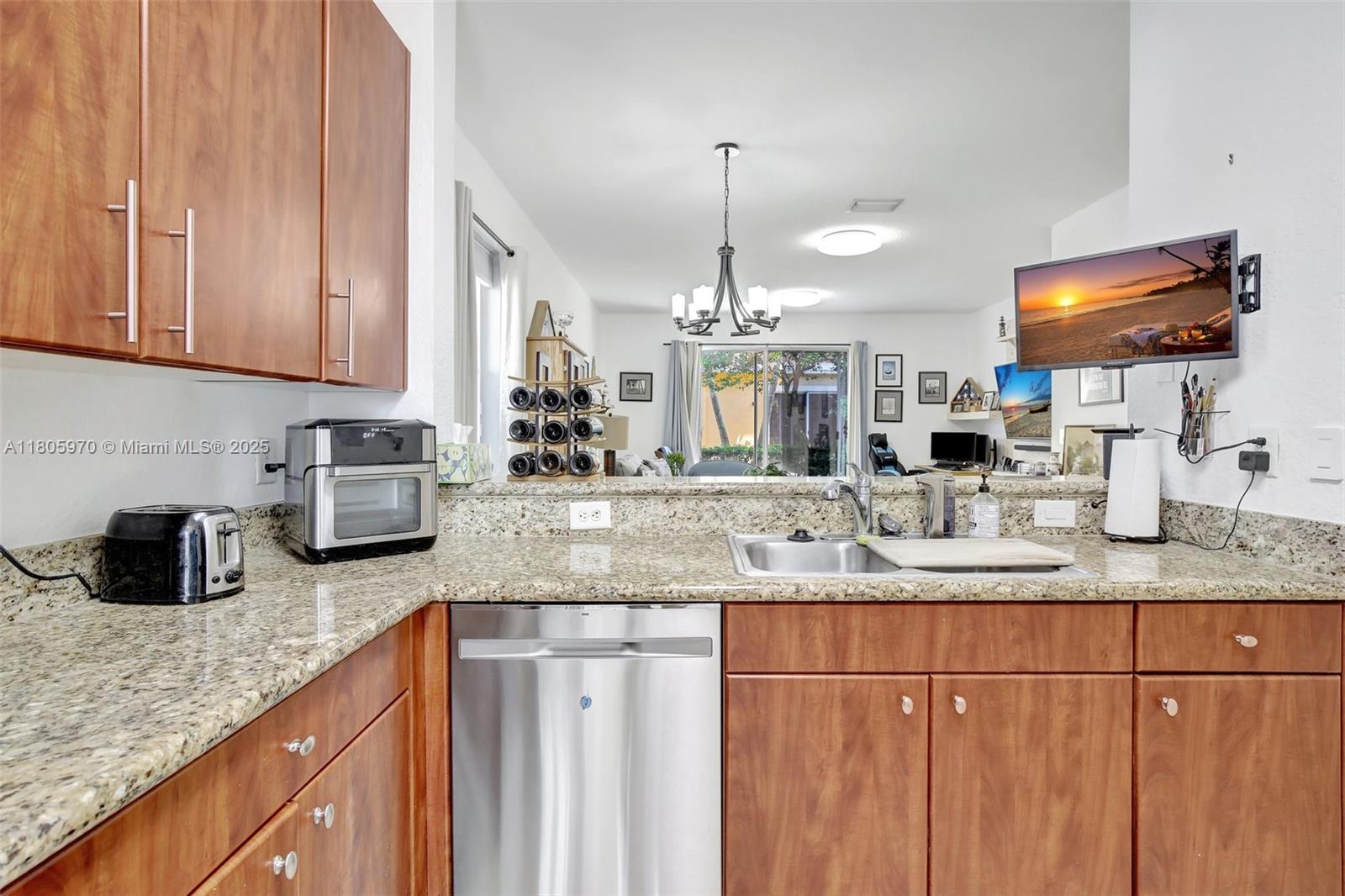 8999 Southwest 18th Street, Unit 1401 Miramar, FL 33025 - Photo 44 of 51 a kitchen with granite countertop a sink a counter space appliances and cabinets