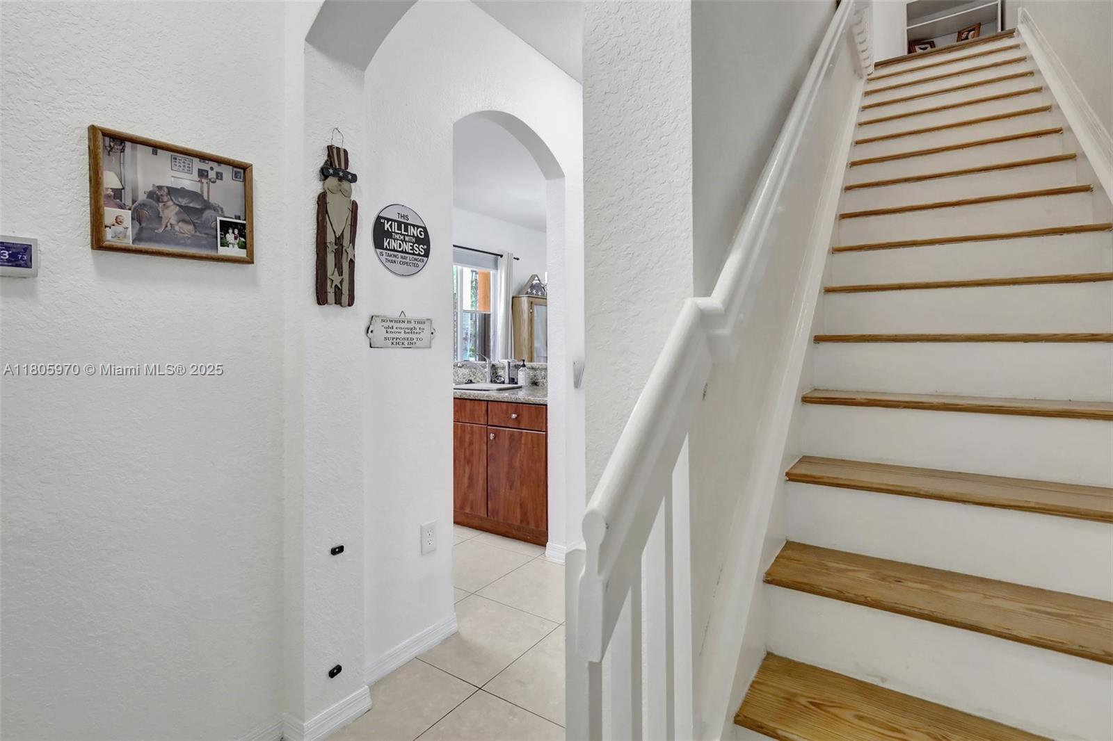 8999 Southwest 18th Street, Unit 1401 Miramar, FL 33025 - Photo 46 of 51 a view of staircase with lots of frames on wall and a window