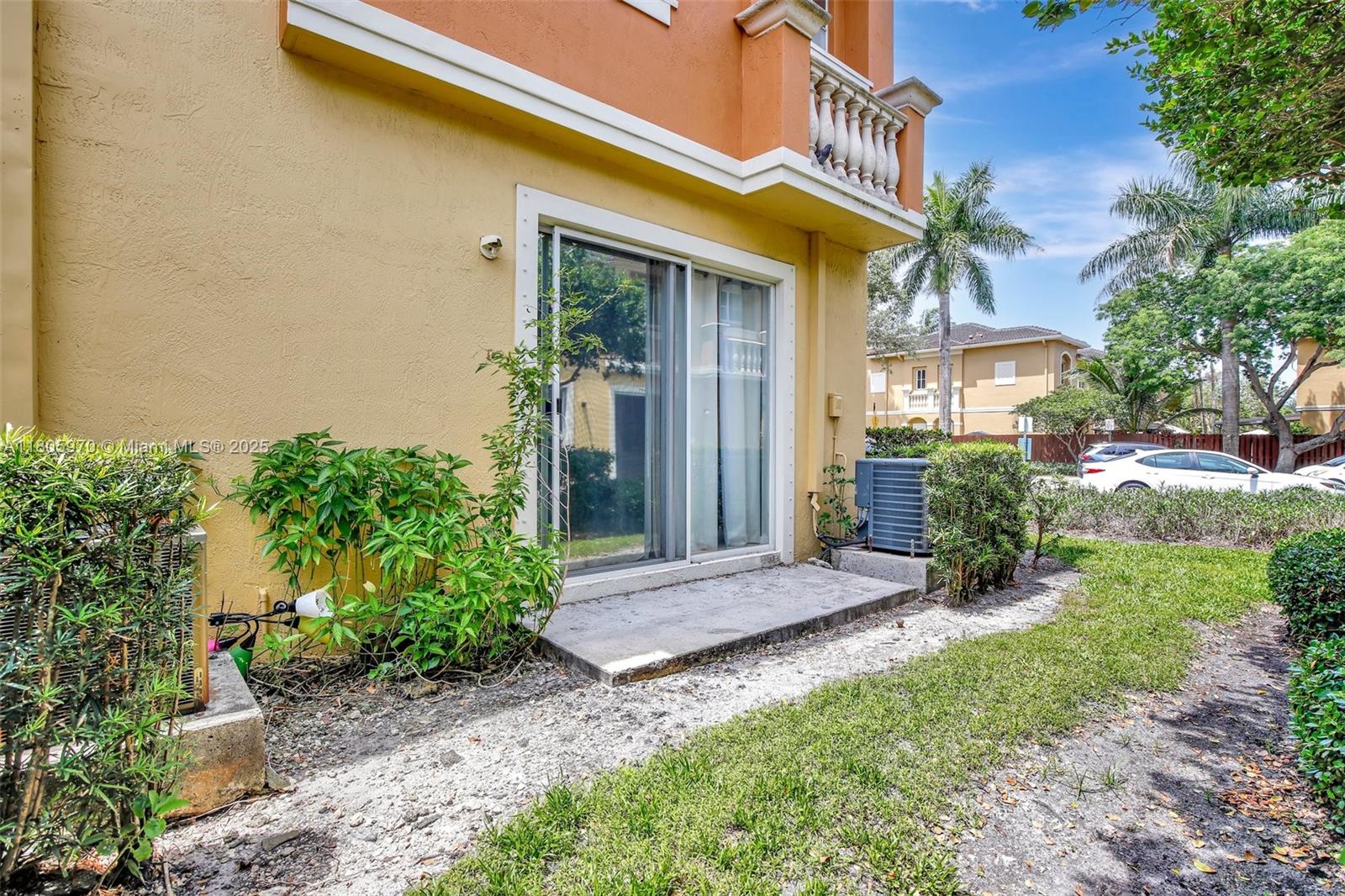 8999 Southwest 18th Street, Unit 1401 Miramar, FL 33025 - Photo 7 of 51 a view of a house with brick walls and a yard with plants