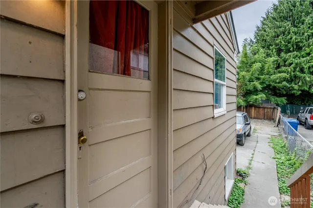 a view of a street with stairs and wooden fence