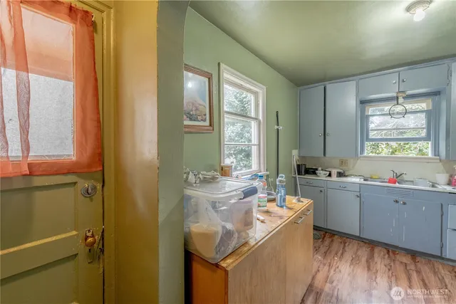 a kitchen with cabinets and wooden floor
