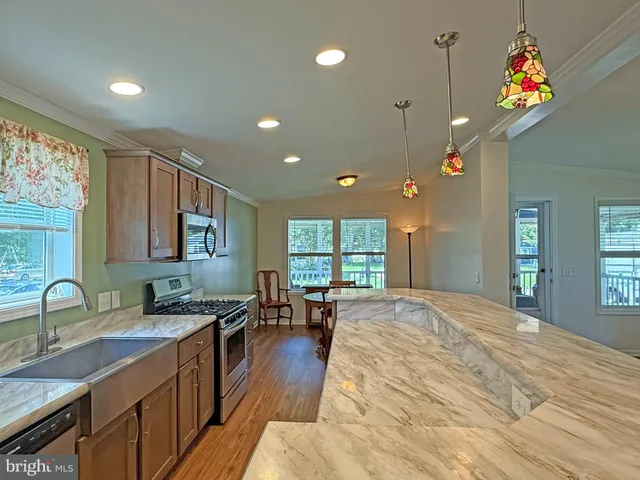 a kitchen with a sink a refrigerator and wooden floor