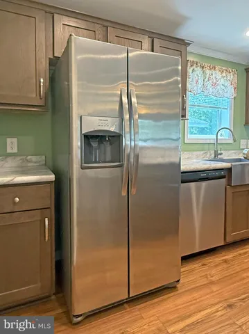 a kitchen with stainless steel appliances granite countertop a refrigerator a sink a stove and a kitchen island