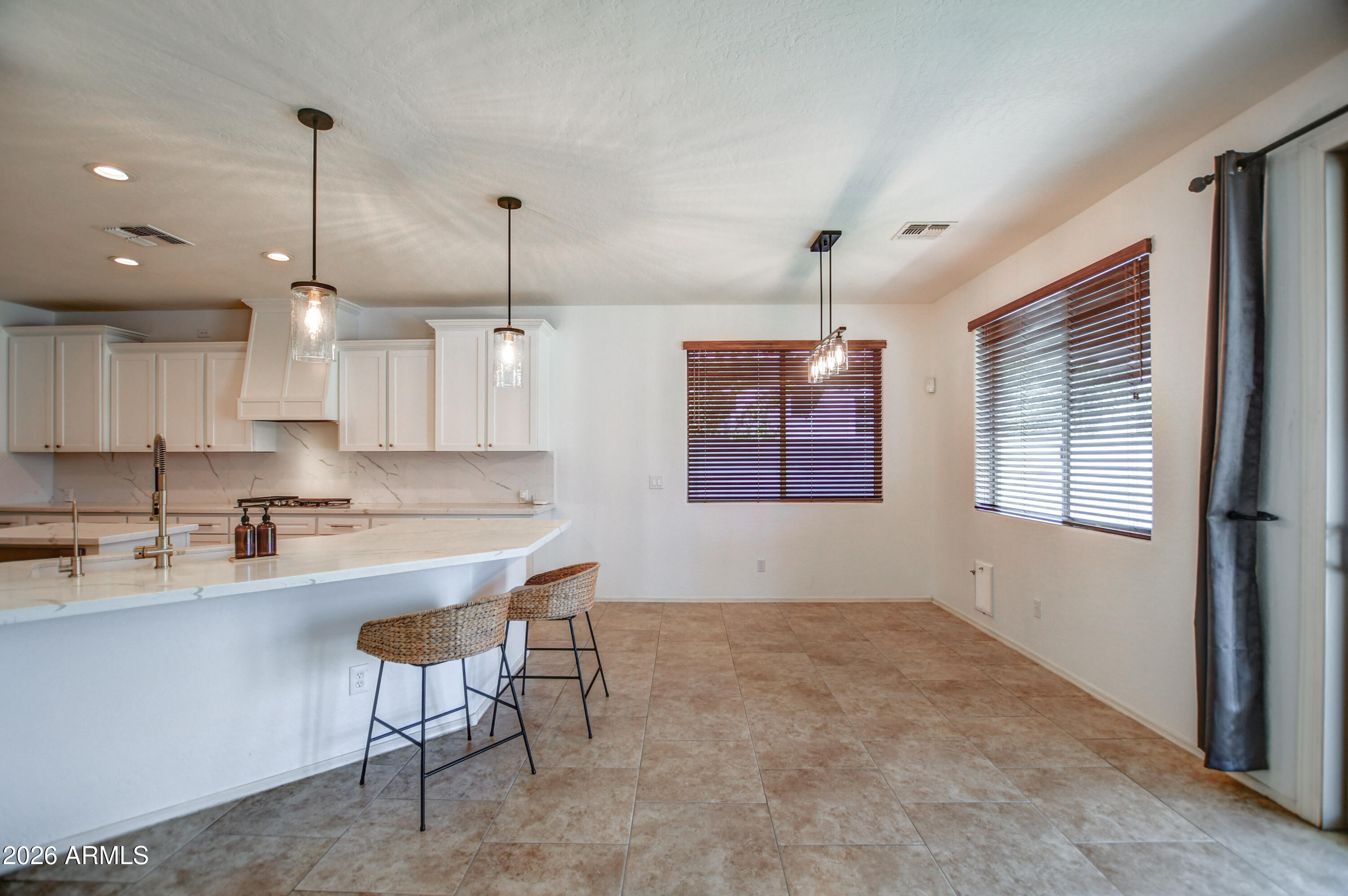 3078 East Muirfield Street Gilbert, AZ 85298 - Photo 30 of 92 a kitchen with kitchen island a stove a sink a center island a stove and a window