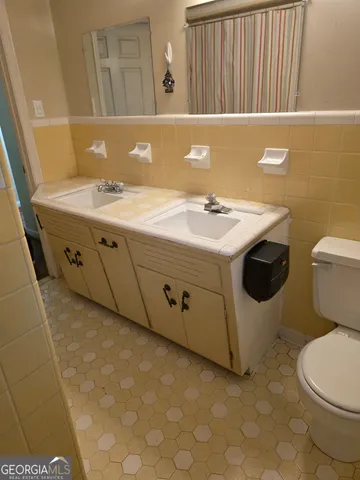 a bathroom with a sink a toilet and a mirror