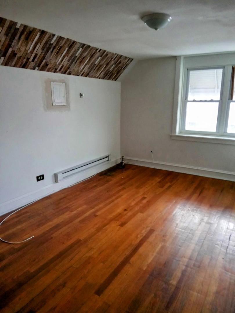 8446 South May Street Chicago, IL 60620 - Photo 3 of 6 an empty room with wooden floor and windows