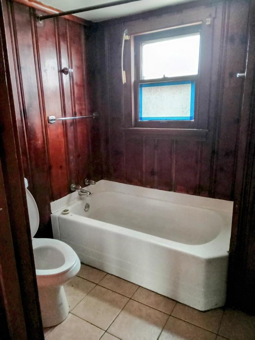 8446 South May Street Chicago, IL 60620 - Photo 6 of 6 a bath tub sitting next to a white toilet