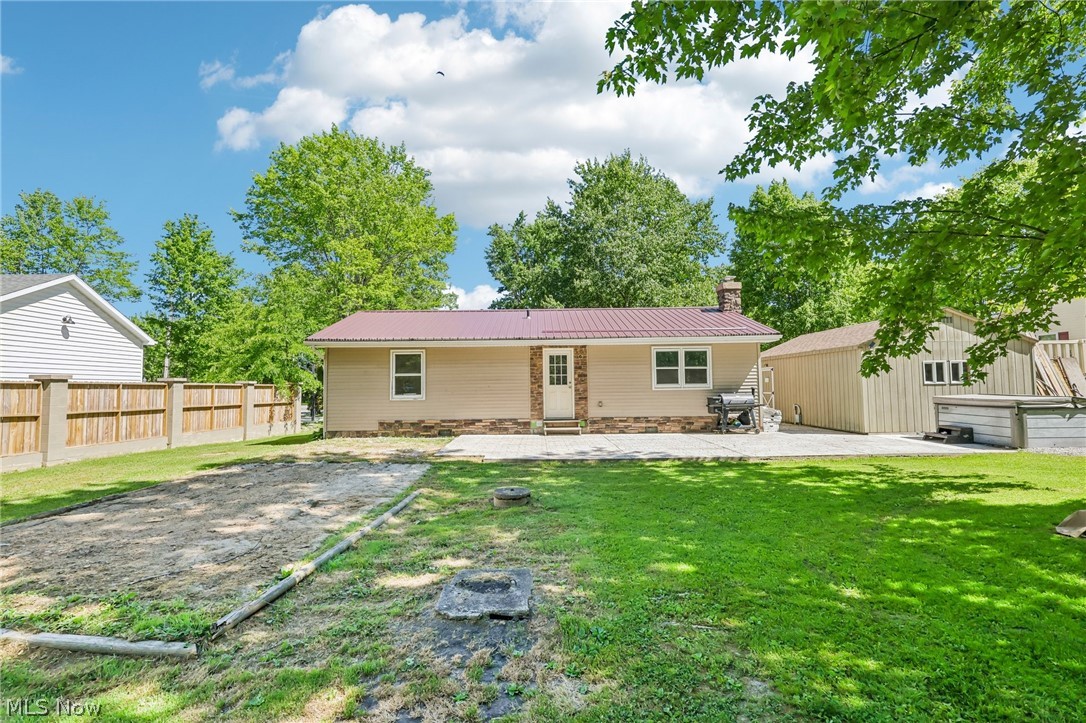 2960 Rome Rock Creek Road Rock Creek, OH 44084 - Photo 10 of 49 Expansive backyard featuring a manicured lawn, a detached storage building, and a stone-look paver patio