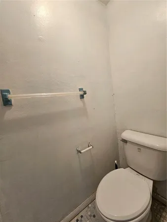 a white toilet sitting next to a shower