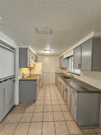 a large white kitchen with a stove a sink dishwasher and a refrigerator