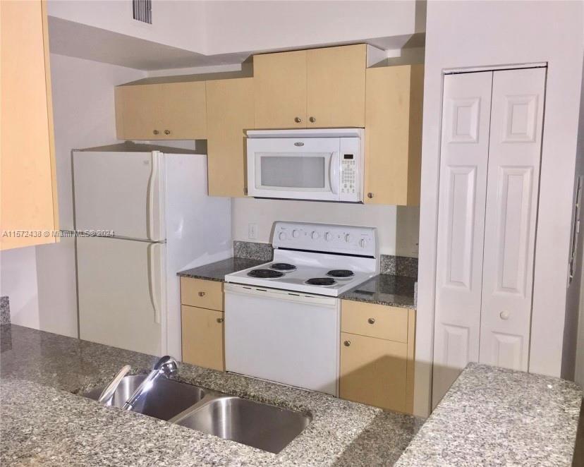 a kitchen with a sink stove and refrigerator