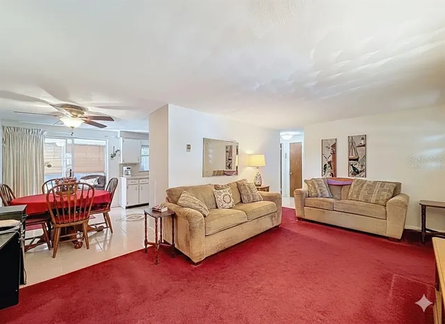a living room with furniture a dining table and chairs with a large window