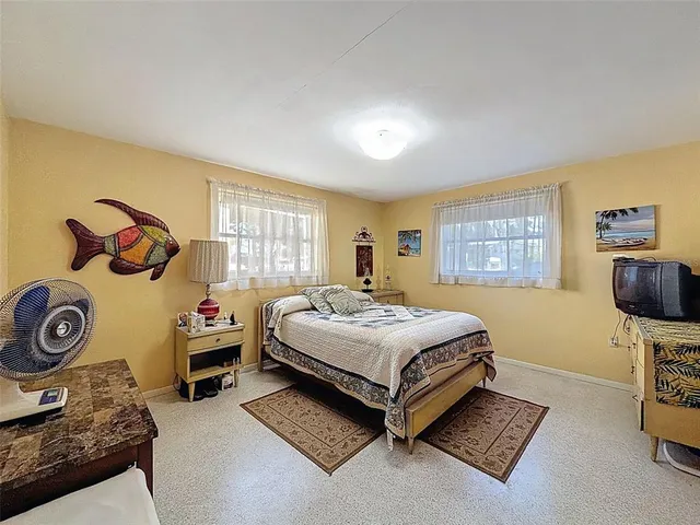 a bedroom with a bed and a tv on the dresser