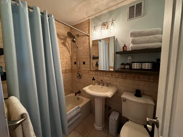 a bathroom with sink a toilet a mirror and shower