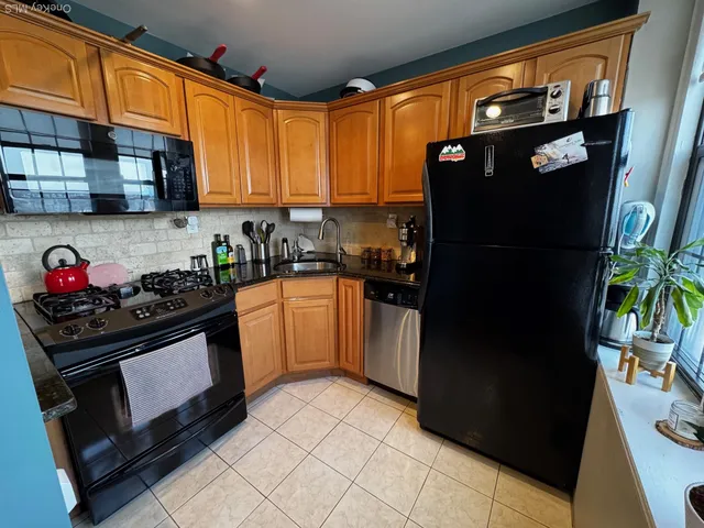 a kitchen with stainless steel appliances granite countertop a refrigerator and a stove