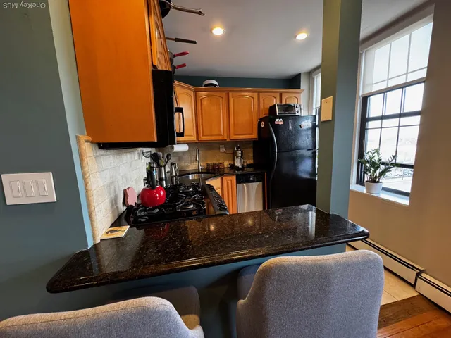 a kitchen with stainless steel appliances granite countertop a sink refrigerator and window