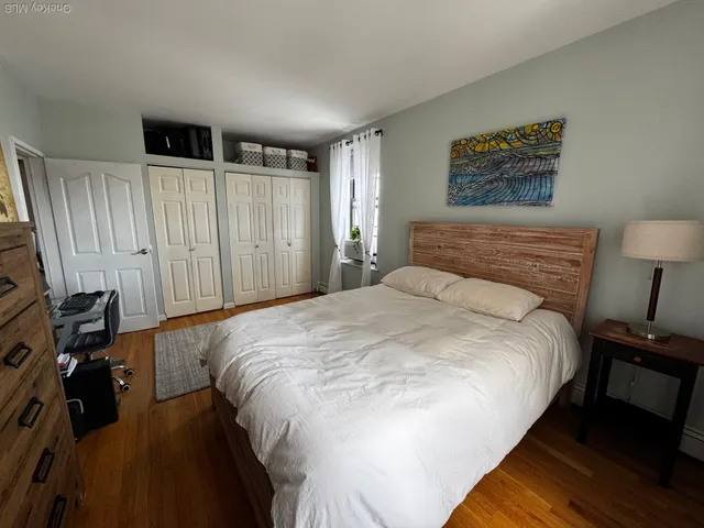 a bedroom with a bed and a flat tv screen on dresser