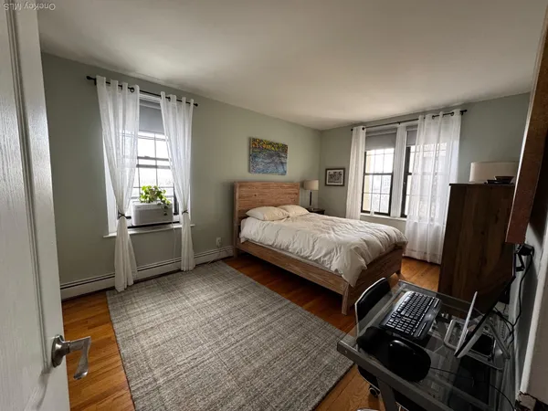 a bedroom with a bed next to a window