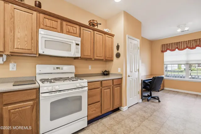 a view of a kitchen with kitchen island and stainless steel appliances