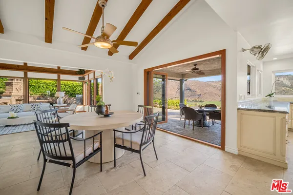 a large white kitchen with lots of counter space and windows