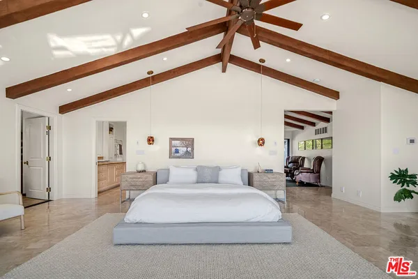 a bedroom with furniture and large windows