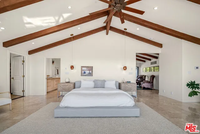 a bedroom with furniture and large windows