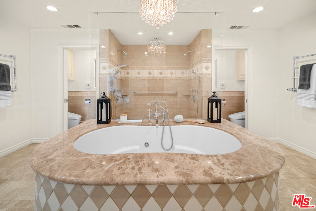 11875 Pradera Road Santa Rosa Valley, CA 93012 - Photo 20 of 35 a bathroom with a tub a sink and a chandelier