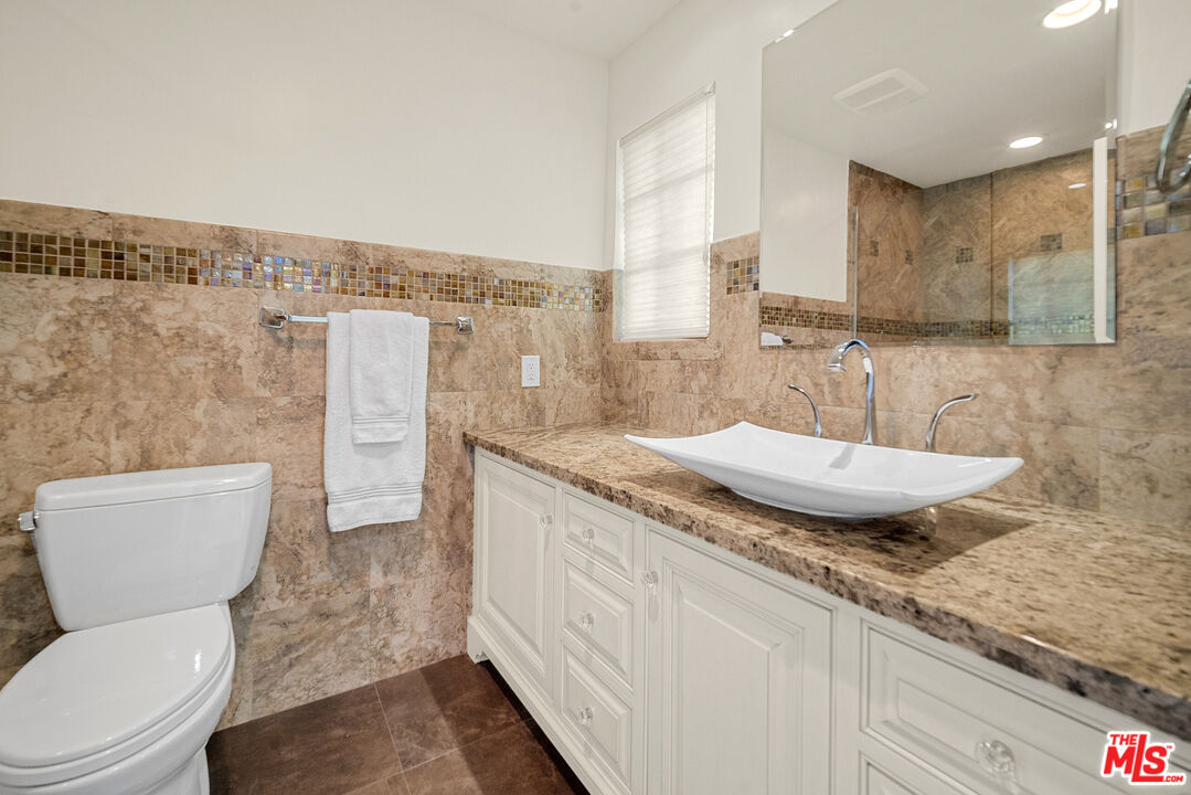 11875 Pradera Road Santa Rosa Valley, CA 93012 - Photo 31 of 35 a bathroom with a granite countertop sink a toilet a mirror and shower