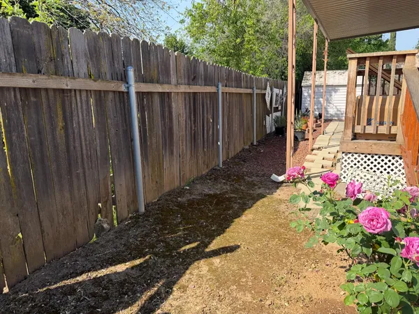 a view of small garden with wooden fence