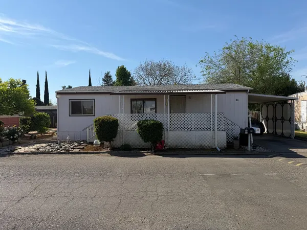 a view of a house with backyard and sitting area