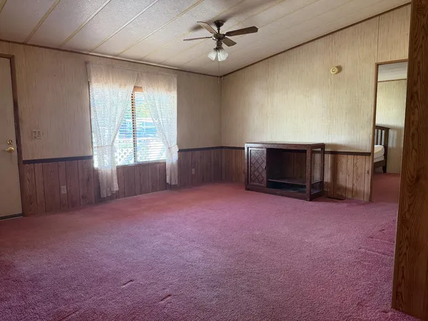 an empty room with windows and fireplace