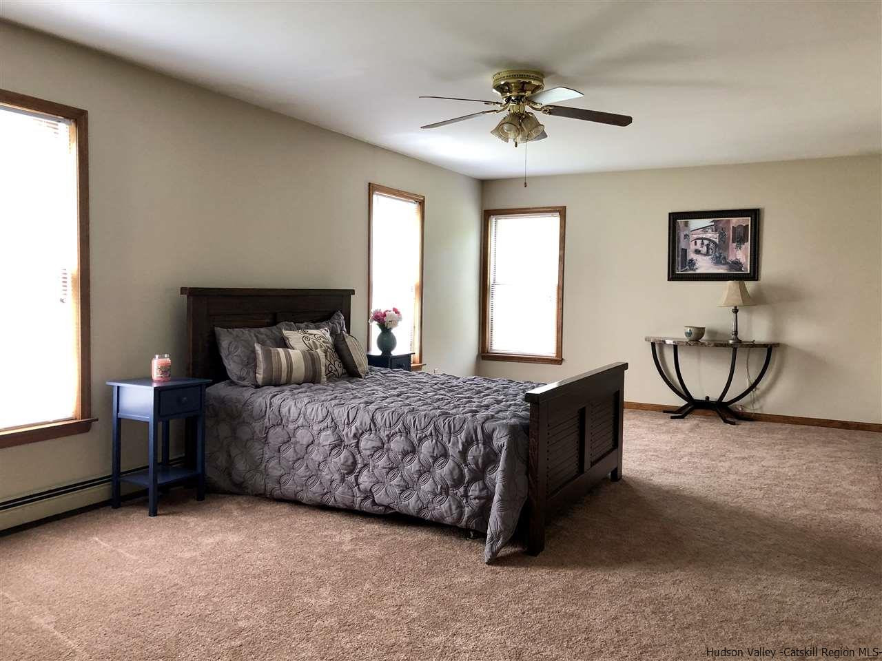 190 Buck Road Stone Ridge, NY 12484 - Photo 16 of 33 a bedroom with a bed and a chandelier