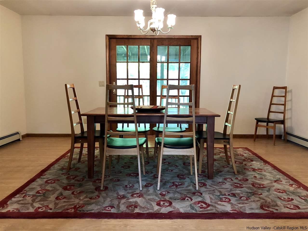 190 Buck Road Stone Ridge, NY 12484 - Photo 8 of 33 a dining room with wooden floor and a rug