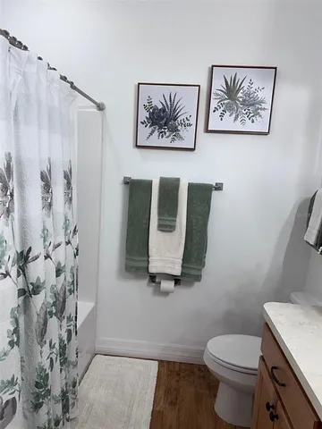 a bathroom with a toilet and a shower curtain