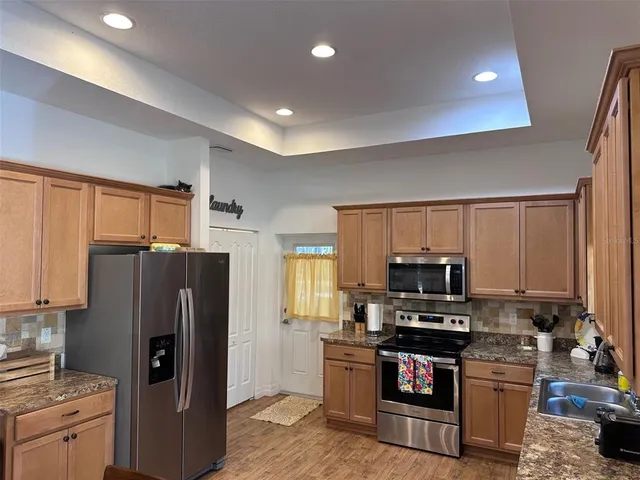 a kitchen with stainless steel appliances granite countertop a refrigerator stove and microwave