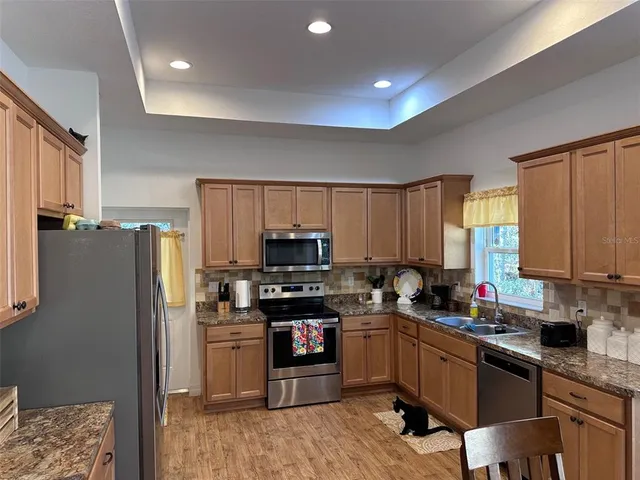 a kitchen with stainless steel appliances granite countertop a refrigerator stove top oven a sink and dishwasher