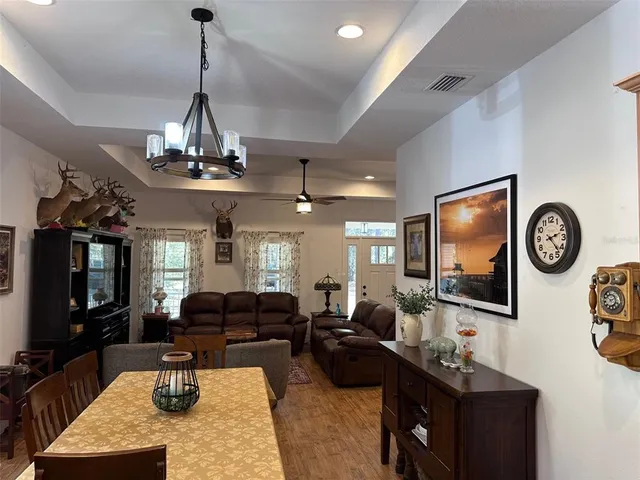 a living room with furniture a chandelier and a flat screen tv