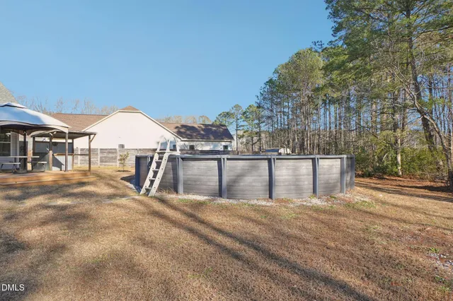 a swimming pool with an outdoor space and seating area