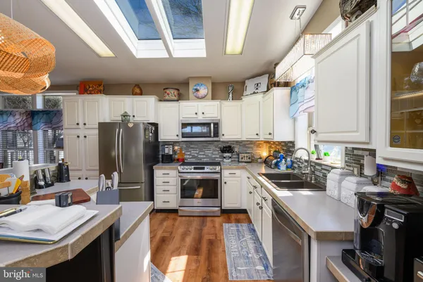 a kitchen with stainless steel appliances a stove refrigerator sink and cabinets