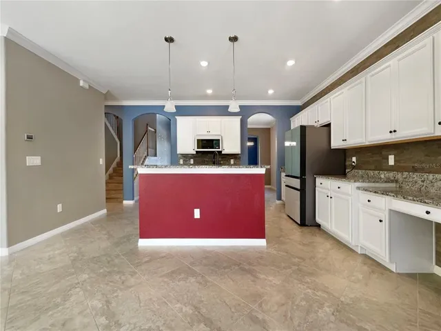 a kitchen with stainless steel appliances kitchen island granite countertop a refrigerator and a stove top oven