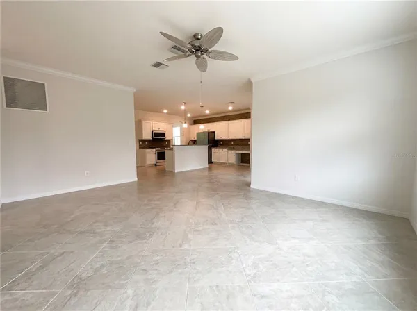 an empty room with wooden floor and ceiling fan