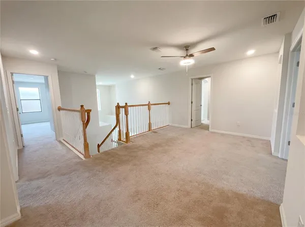 a view of a big room with windows and ceiling fan