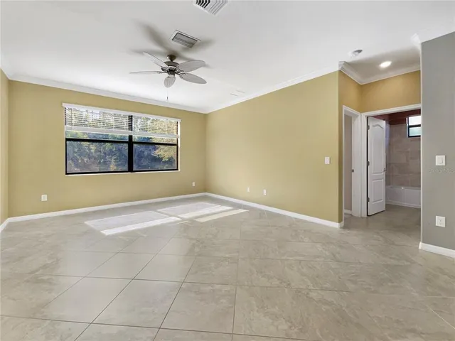 an empty room with windows and fan