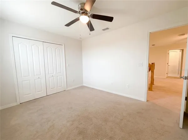 an empty room with fan and windows