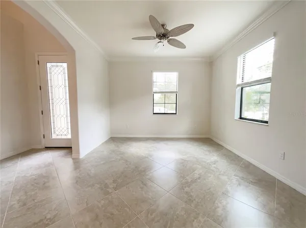 an empty room with windows and fan